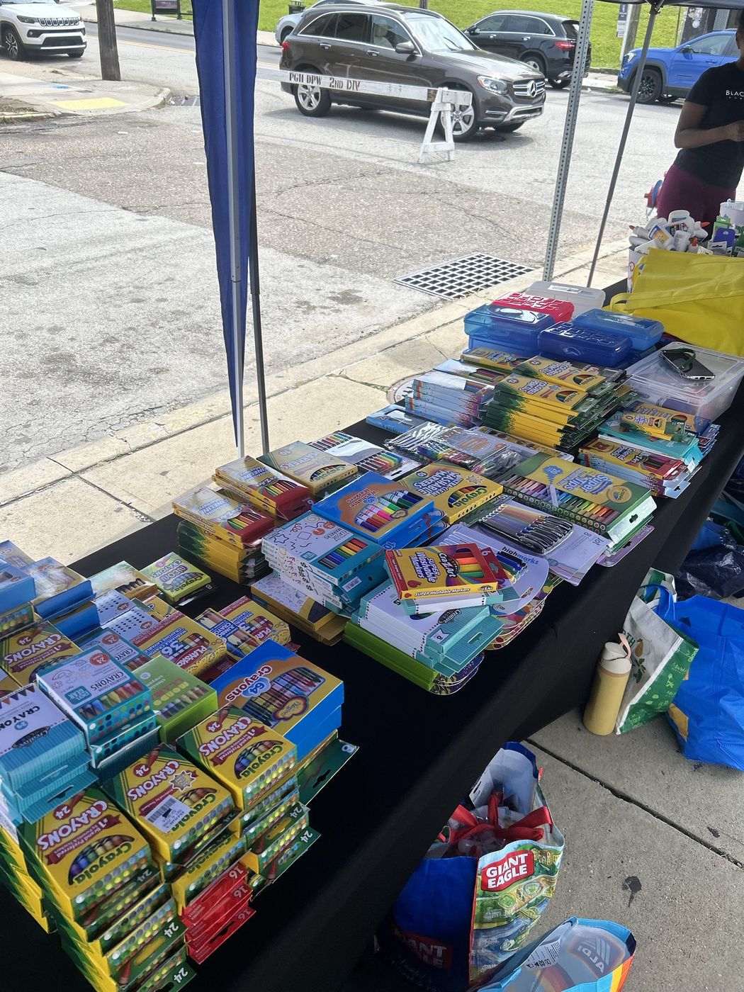 A table stacked with crayons, markers, and school supplies for families