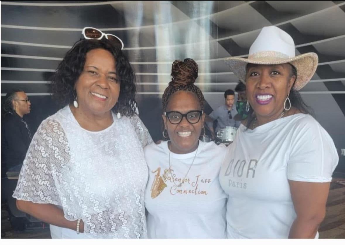Three women smiling together at a jazz event