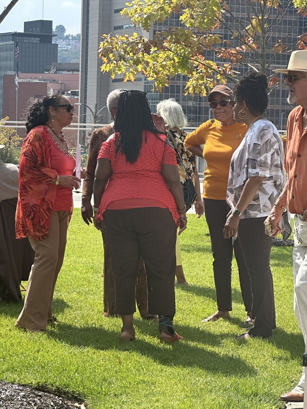 Older adults talking together on a lawn at an outdoor community event