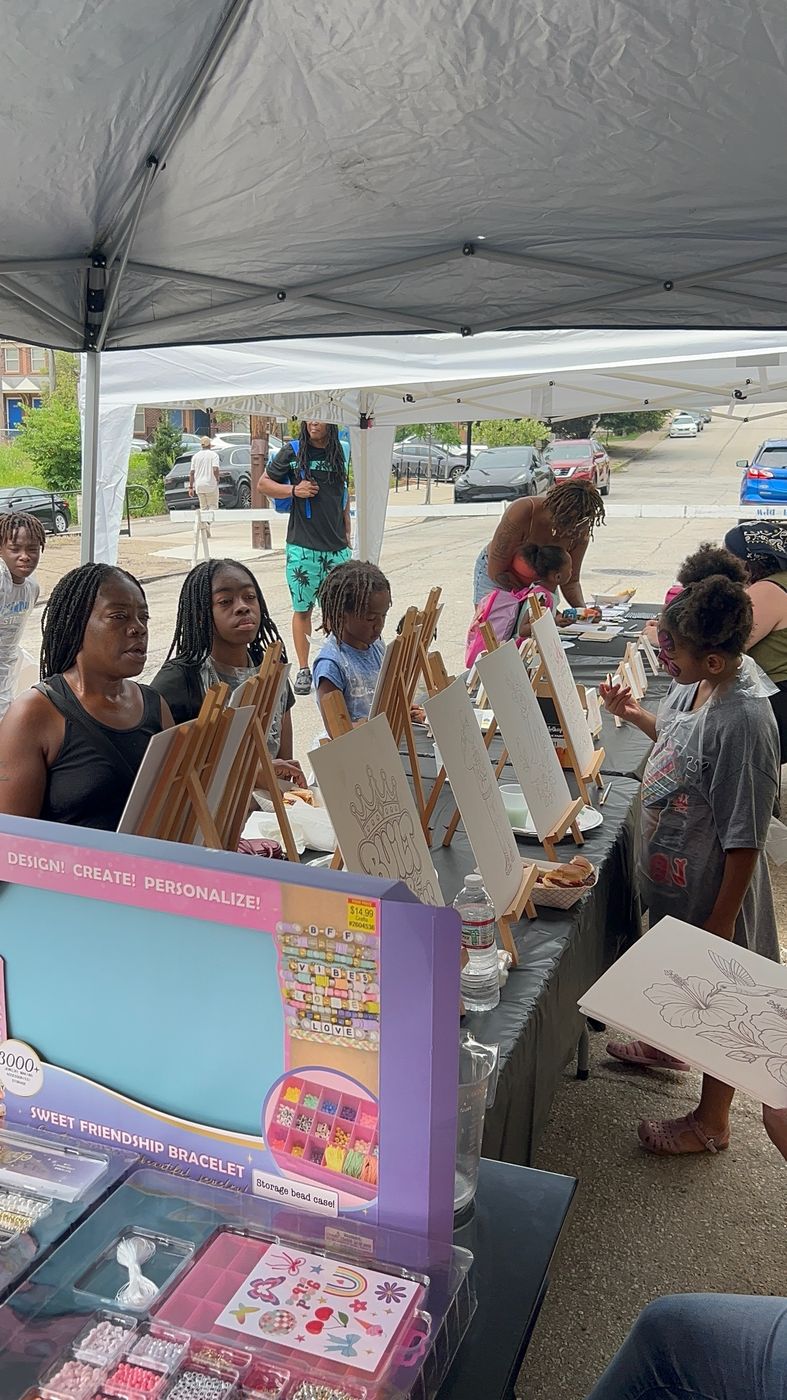A family at an art table with canvases on easels